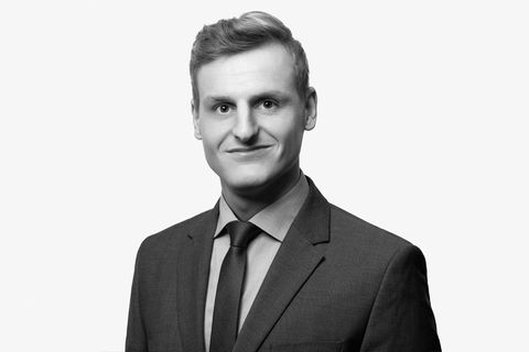 Auf der schwarz-weißen Fotografie ist der Mitarbeiter Timo Köth abgebildet. Er trägt Anzug und ist Master of Engineering und Sachverständiger für Immobilienbewertung bei der Partnerschaft für Immobilienbewertung.